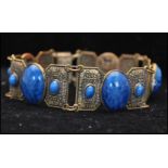 A 1930s Art Deco signed Czech Egyptian revival bracelet set with satin glass blue cabochons.