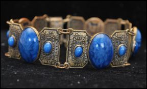 A 1930s Art Deco signed Czech Egyptian revival bracelet set with satin glass blue cabochons.