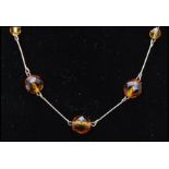 An early 20th century rolled gold and topaz glass necklace with hook fastener. Measures 16 inches.