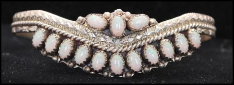 A vintage silver and opal cuff bangle bracelet set with opal cabochons with diamond cut