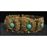 A 1920's Czech gold tone bracelet set with peking glass cabochons with filigree and foliate work