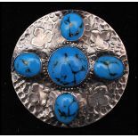 An early 20th century large Ruskin style sterling silver brooch pin having turquoise style cabochons