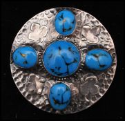 An early 20th century large Ruskin style sterling silver brooch pin having turquoise style cabochons