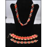 A 1950s thermoset necklace and two bracelets. The gold-tone necklace having coral and brown