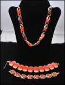 A 1950s thermoset necklace and two bracelets. The gold-tone necklace having coral and brown
