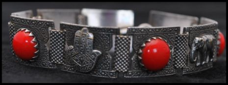 A vintage Asian silver bracelet having red cabochons and elephant motifs. Measures 7 inches.