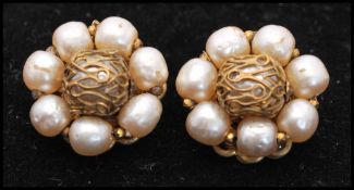 A pair of signed Miriam Haskell earrings set with faux pearl with filigree work and metal findings