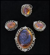 A vintage signed Whiting and Davis amber glass cameo parure set consisting of a gold-tone necklace