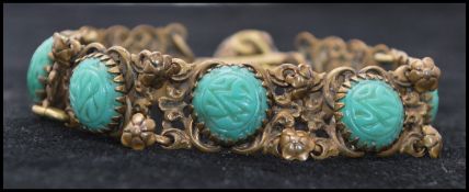A 1920s Egyptian revival green cabochon bracelet with hook clasp and ball finial. Measures 7 1/2