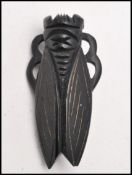 A 1920s French carved horn beetle cicada (black / dark brown). Marked Deposé. Measures 2 inches.