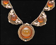 A 1920s Czech filigree and amber glass cabochon necklace having round amber glass cabochons with