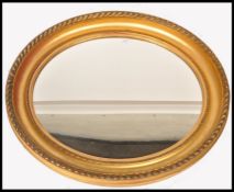 A 19th century oval gilt wood mirror having deep carved frame with  beaded and gadrooned borders