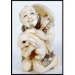 JAPANESE MEIJI PERIOD CARVED IVORY NETSUKE OF MERCHANT MAN AND RABBIT