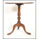 A 19th century mahogany circular tilt top wine / occasional table being raised on tripod splayed leg