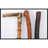A collection of three 20th Century walking sticks / canes to include a bamboo stick having a