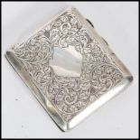 A 1920's hallmarked silver cigarette case by J. C. L.td with scrolled foliate engraving to the
