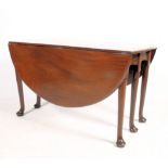 A 19th century solid mahogany drop leaf / gate leg dining table having six legs opening to reveal
