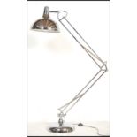 A vintage 20th century floor standing anglepoise style lamp raised on a circular base with conical