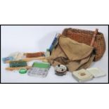 A vintage 20th century wicker fishing hamper bag with canvas hamper stocked with various fishing