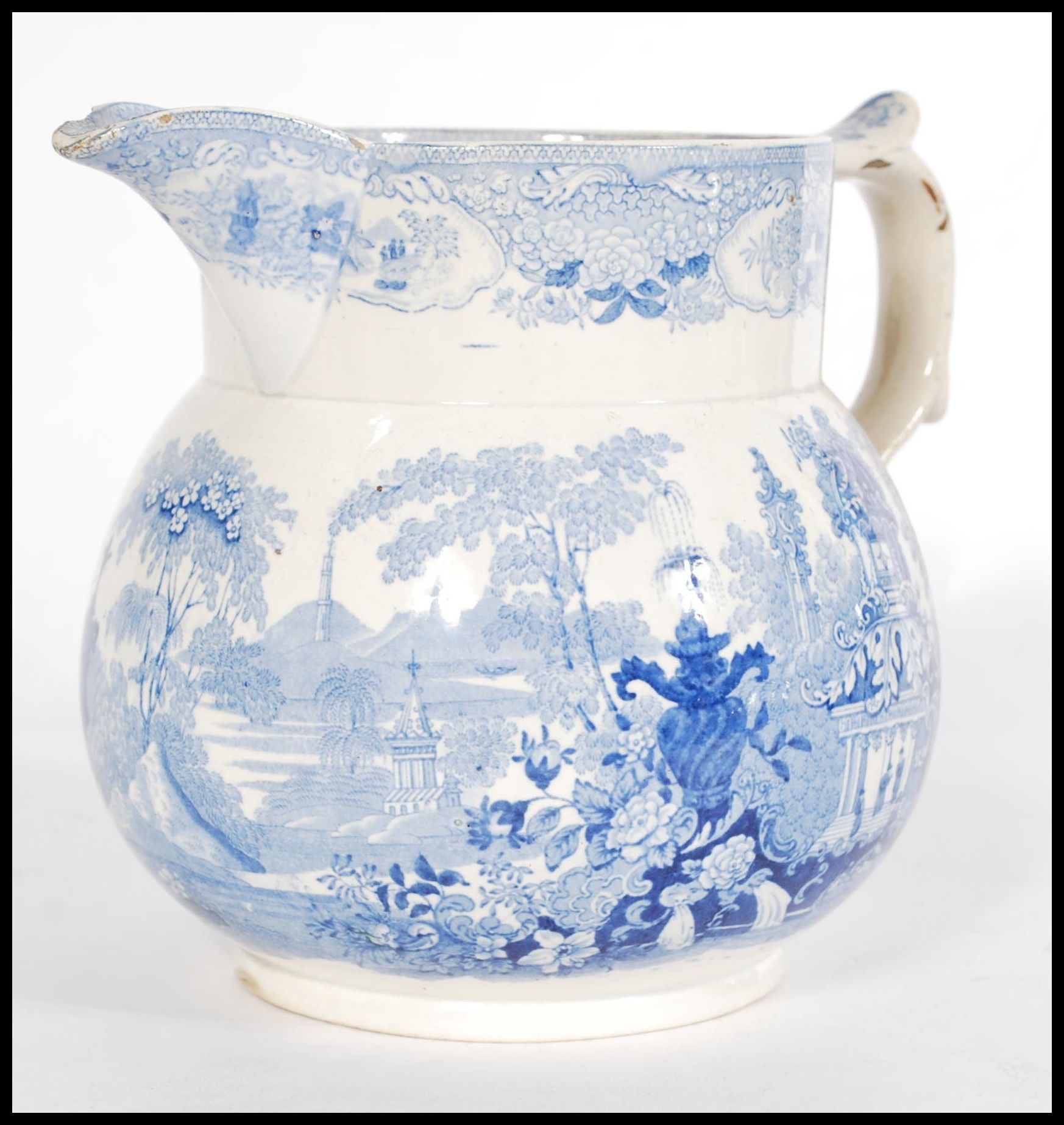 A 19th century Staffordshire Pearlware jug having a scrolled shaped handle with a blue and white