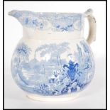 A 19th century Staffordshire Pearlware jug having a scrolled shaped handle with a blue and white