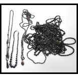 A large collection of vintage costume jewellery black glass necklaces in a wide range of lengths