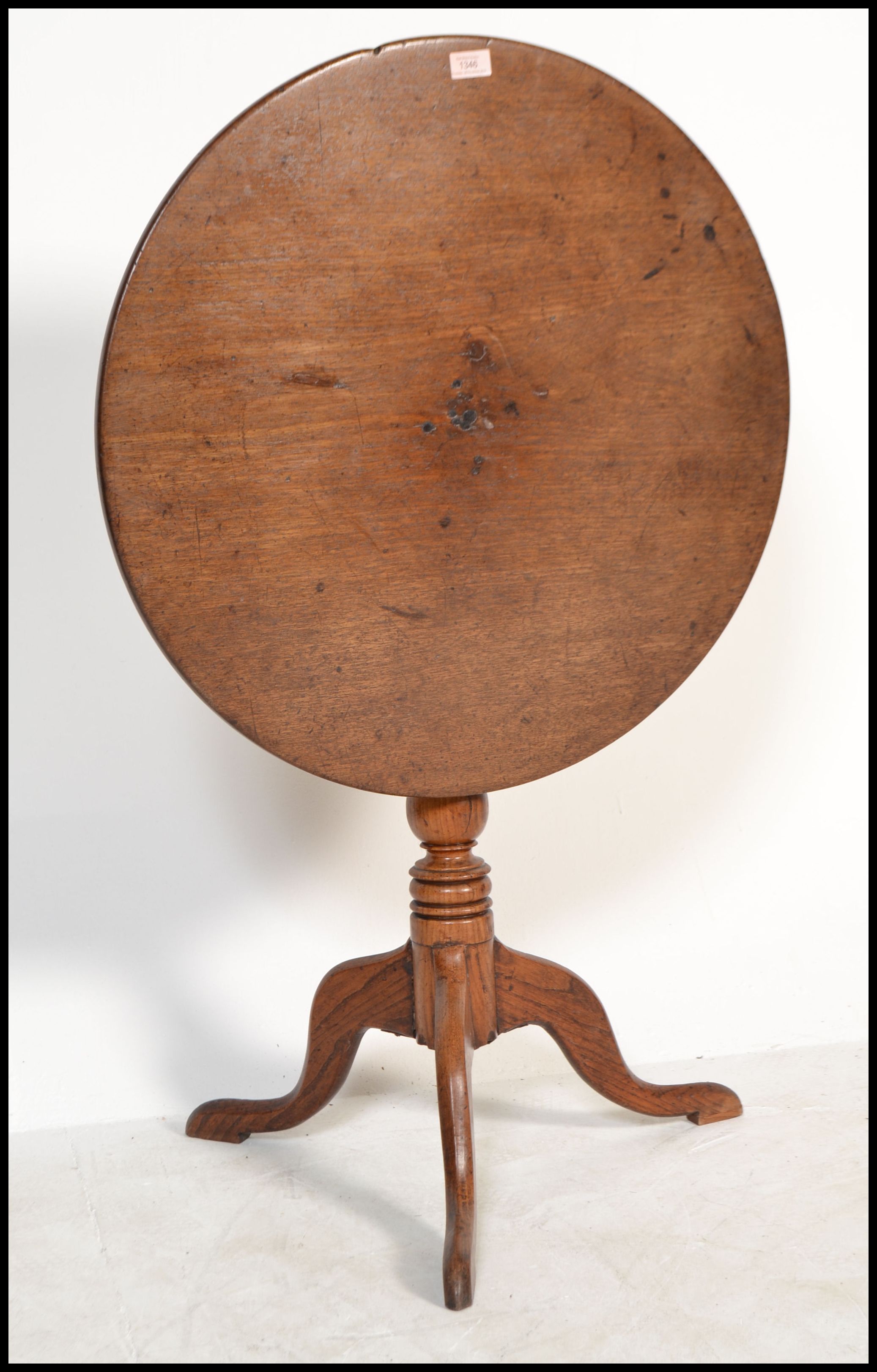 A 19th century mahogany tilt top wine / occasional table being raised on splayed legs, turned column