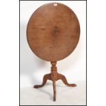 A 19th century mahogany tilt top wine / occasional table being raised on splayed legs, turned column