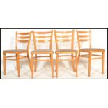 A set of four vintage retro 20th century beech 1960's utility dining chairs. Raised on tapered