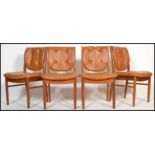 A set of 4 mid century retro teak wood and faux tan leather dining chairs. Raised on shaped legs