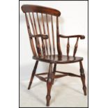 A Victorian 19th century beech and elm wood windsor chair / armchair being raised on turned legs