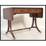 A George III early 19th century mahogany crossbanded drop leaf sofa table desk. Raised on reeded