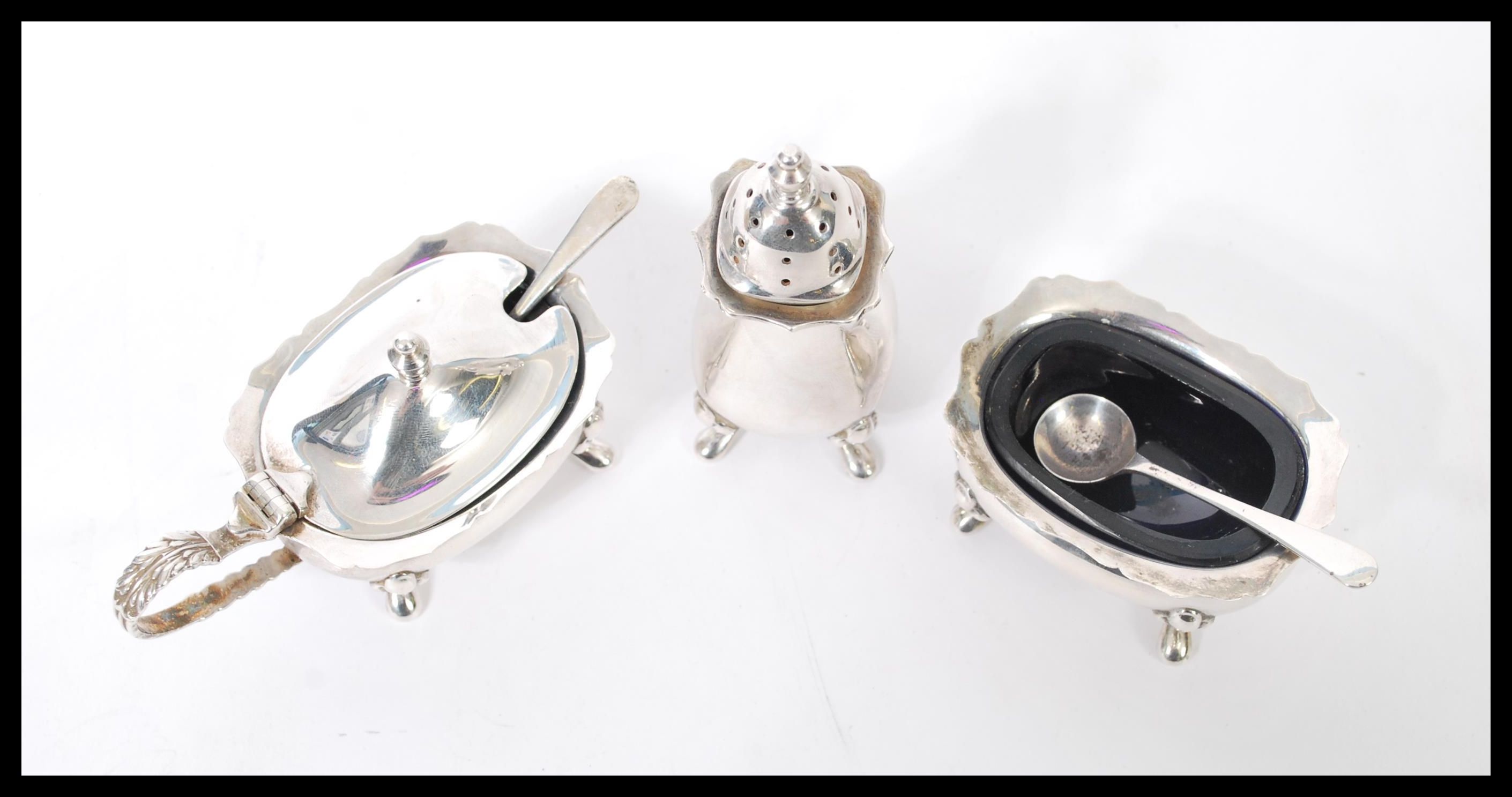 A 20th century hallmarked silver three piece condiment cruet set consisting of a tall pepperette, - Image 2 of 4