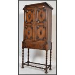 A 1920's Jacobean revival oak barleytwist cabinet bookcase on stand. Raised on bell pad feet with