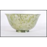 A Chinese jade tea / finger bowl / libation cup of typical form having a mottled and clear