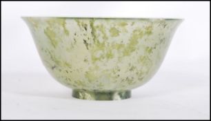 A Chinese jade tea / finger bowl / libation cup of typical form having a mottled and clear