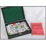 A 20th century Chinese Mahjong set in fitted case having white and green stone playing pieces.