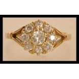 An 18ct gold and diamond ring having a central diamond with a halo of smaller diamonds. Approx