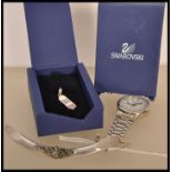 A Swarovski silver charm / pendant in the form of a skateboard with inlaid blue and red crystals,