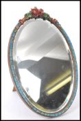A 20th Century oval Barbola mirror having a carved wood floral frame with carved florals to the