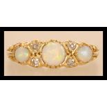 An hallmarked 18ct gold opal and diamond ring having three opal cabochons with four diamond spacers.