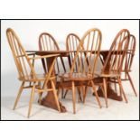 A retro mid 20th century Ercol refectory dining table and chairs being raised on angled tapering