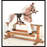 A 20th century antiques style childs upholstered rocking horse. Raised on a solid wooden glider with