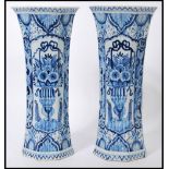 A pair of 18th Century Dutch trumpet form delft vases, with a hand painted blue and white pattern of