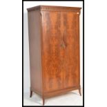 A mid century Maple Co flame mahogany double wardrobe. Raised on bracket feet with twin full