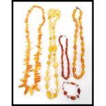A group of five amber type necklaces consisting of a yellow bead necklace, baroque amber type