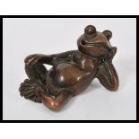 An early 20th century bronze figurine of a cheeky reclining toad. Makers stamps to base.