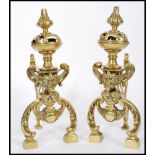 A pair of 19th century cast brass fireside dogs raised on block feet with scrolled legs. Grotesque