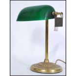 A vintage 20th century gilt brass bankers lamp raised on circular base with adjustable green glass