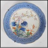 A late 19th century Chinese blue and white porcelain plate having a large blue and white helmet